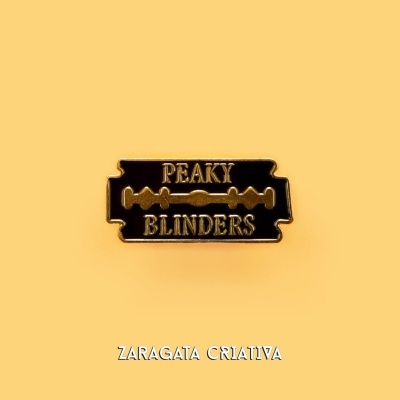 Pin metálico preto e dourado com texto PEAKY BLINDERS sobre fundo amarelo com texto ZARAGATA CRIATIVA