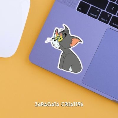 Adesivo do Tom no portátil roxo junto a rato branco sobre fundo amarelo