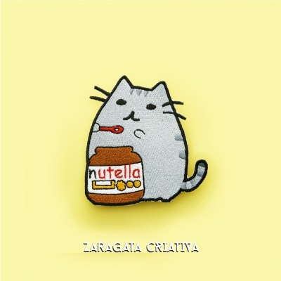 Emblema de gato cinzento com frasco de Nutella em fundo amarelo