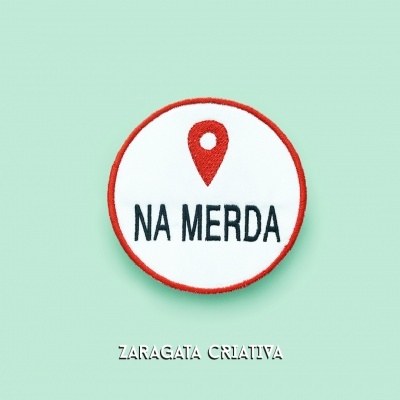 Emblema redondo com símbolo e texto 'NA MERDA'