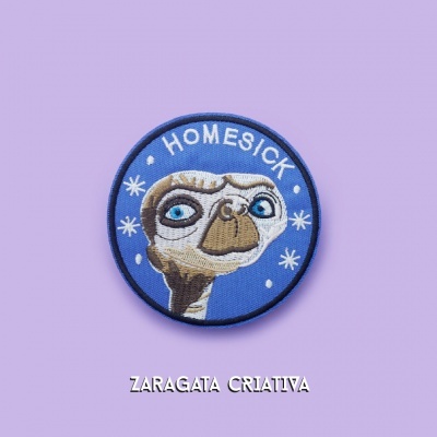 Emblema azul com E.T. e texto HOMESICK