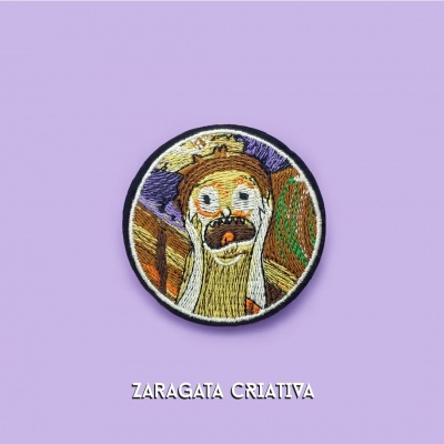 Emblema bordado redondo com personagem surpresa e coroa sobre fundo lilás