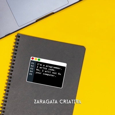 Caderno cinzento com autocolante de código, ao lado de portátil prateado em fundo amarelo