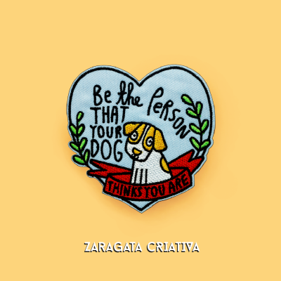 Emblema bordado em formato de coração azul claro com um cão e texto