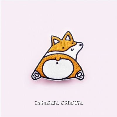 Pino de tecido em forma de raposa sobre fundo rosa claro.