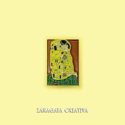 Íman decorativo inspirado em O Beijo de Klimt sobre fundo amarelo com texto Zaragata Criativa.
