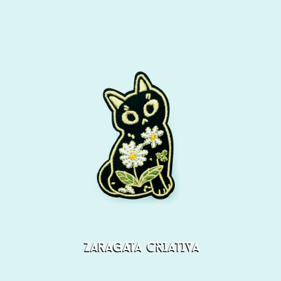 Emblema bordado de gato preto com flores, texto ZARAGATA CRIATIVA
