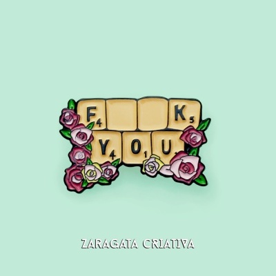 Íman com peças de scrabble e flores decorativas em fundo verde claro