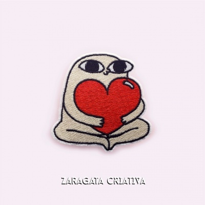 Patch bordado de personagem com coração vermelho sobre fundo rosa