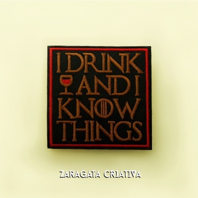 Emblema bordado com frase I DRINK AND I KNOW THINGS, fundo preto e letras castanhas