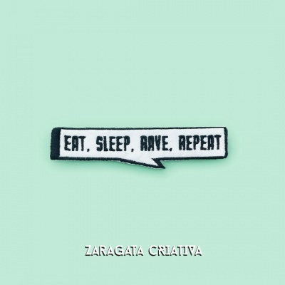 Emblema bordado com texto 'EAT, SLEEP, RAVE, REPEAT' sobre fundo verde claro