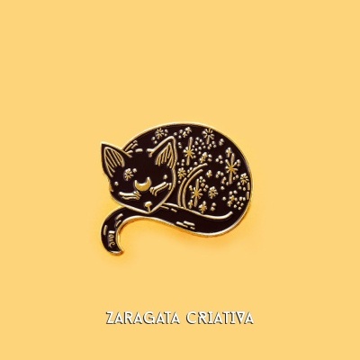 Pin metálico de gato preto com flores douradas sobre fundo amarelo com texto ZARAGATA CRIATIVA