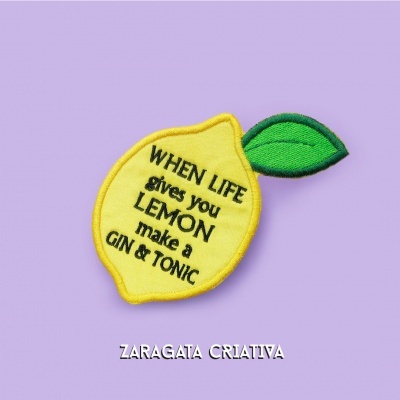 Emblema bordado em forma de limão com texto sobre fundo lilás