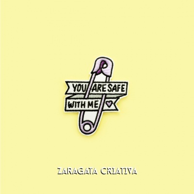 Broche de alfinete rosa claro com texto em inglês em fundo amarelo