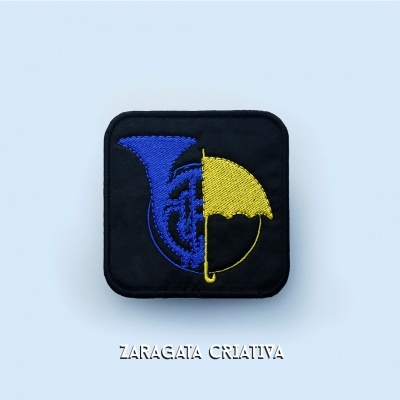 Patch quadrado preto com bordado azul e amarelo de trompa e guarda-chuva