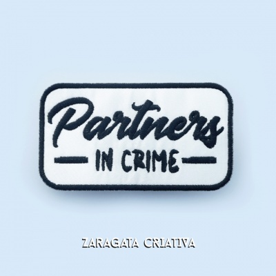 Etiqueta bordada retangular com texto 'Partners IN CRIME'