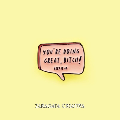 Íman em formato de balão cor-de-rosa com texto motivacional em inglês, sobre fundo amarelo claro.