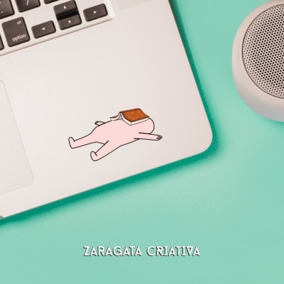 Autocolante personagem com fatia de pão num computador portátil branco