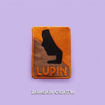Emblema tecido com silhueta de cavalo e texto LUPIN em fundo castanho e laranja sobre fundo lilás