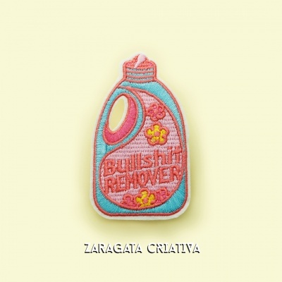 Broche bordado em forma de recipiente de detergente azul e rosa com texto 'Bullshit REMOVER'