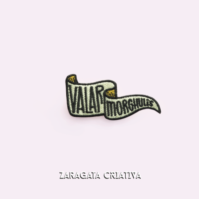 Emblema bordado com texto VALAR MORGHULIS em faixa ondulada