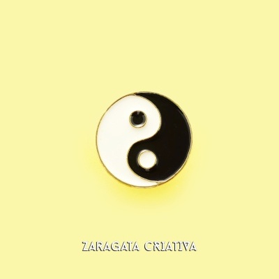 Pino yin-yang preto e branco sobre fundo amarelo com texto ZARAGATA CRIATIVA