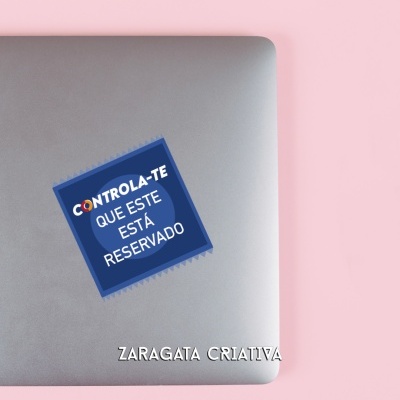 Portátil cinzento com autocolante azul contendo texto em branco, sobre superfície rosa, com lápis de madeira por cima.