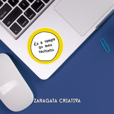 Computador portátil com autocolante amarelo, rato branco e clip azul em fundo azul