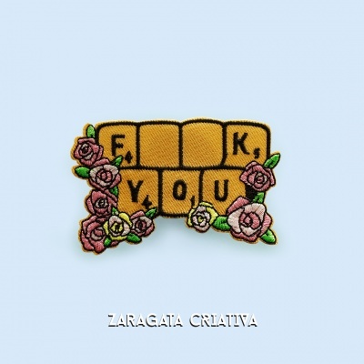 Emblema bordado com quadrados amarelos e flores em fundo azul claro