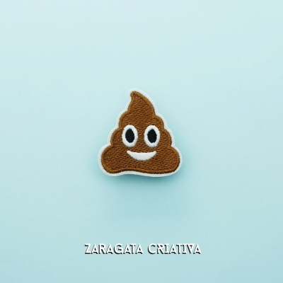 Patch bordado emoji cocó sorridente em fundo azul claro com texto ZARAGATA CRIATIVA