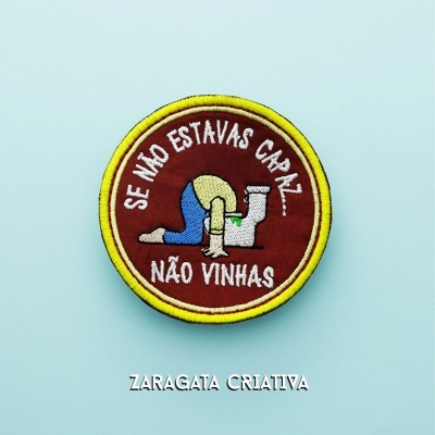 Emblema bordado redondo com frase em português e ilustração de pessoa com a cabeça na sanita