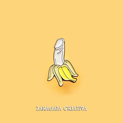 Broche de banana descascada com forma estilizada em fundo amarelo e texto Zaragata Criativa
