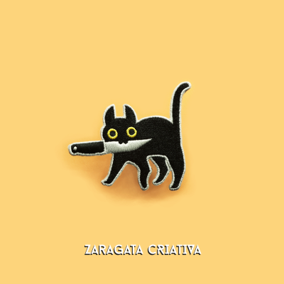 Aplique em forma de gato preto com olhos amarelos sobre fundo laranja