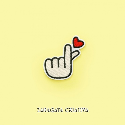 Emblema bordado mão com coração em fundo amarelo