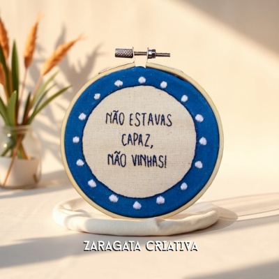 Aro de bordado com frase bordada em azul e creme sobre suporte branco