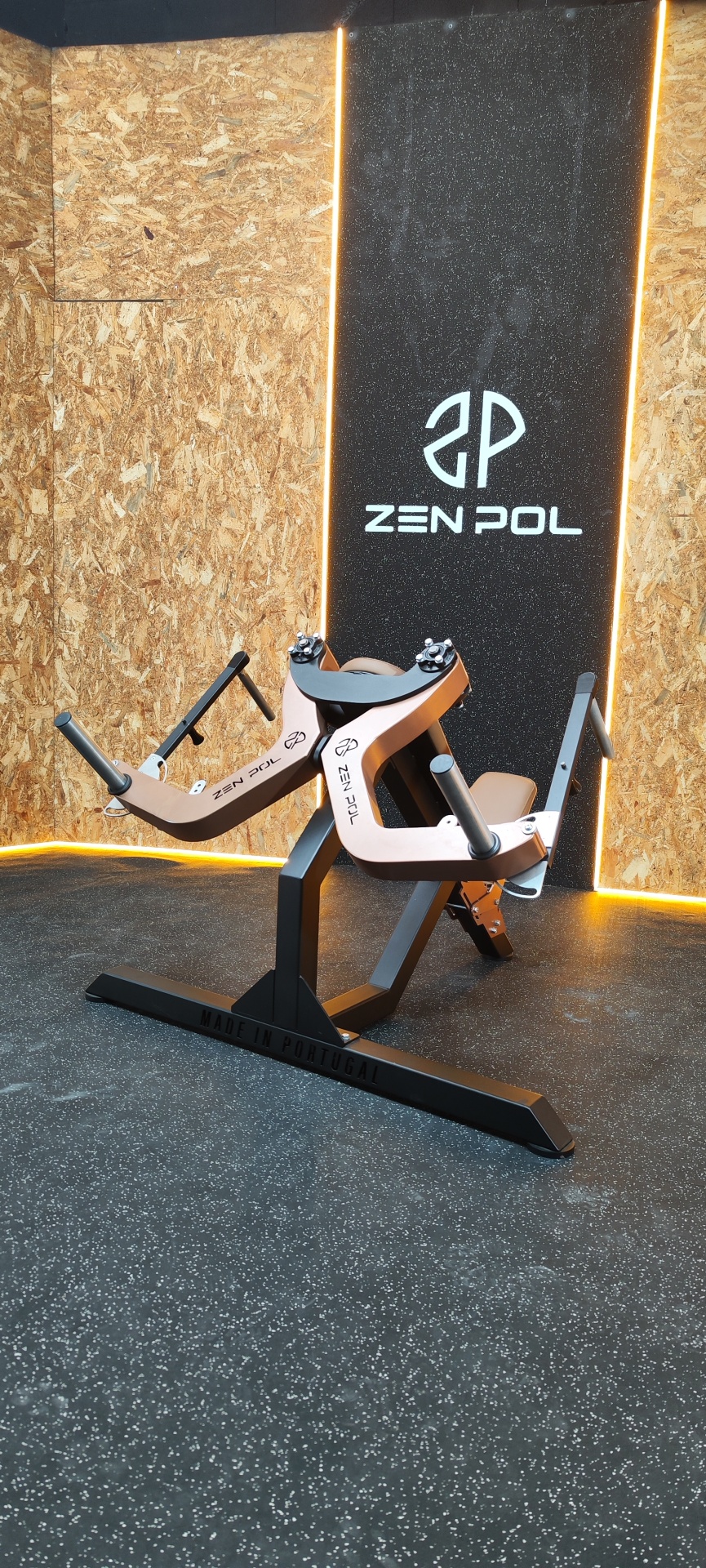 Equipamento de ginásio em metal preto e madeira clara com logotipo Zen Pol e iluminação