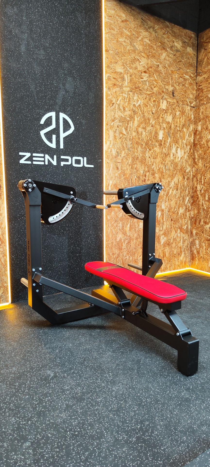 Banco de treino preto com almofadado vermelho, logo ZEN POL no painel preto ao fundo