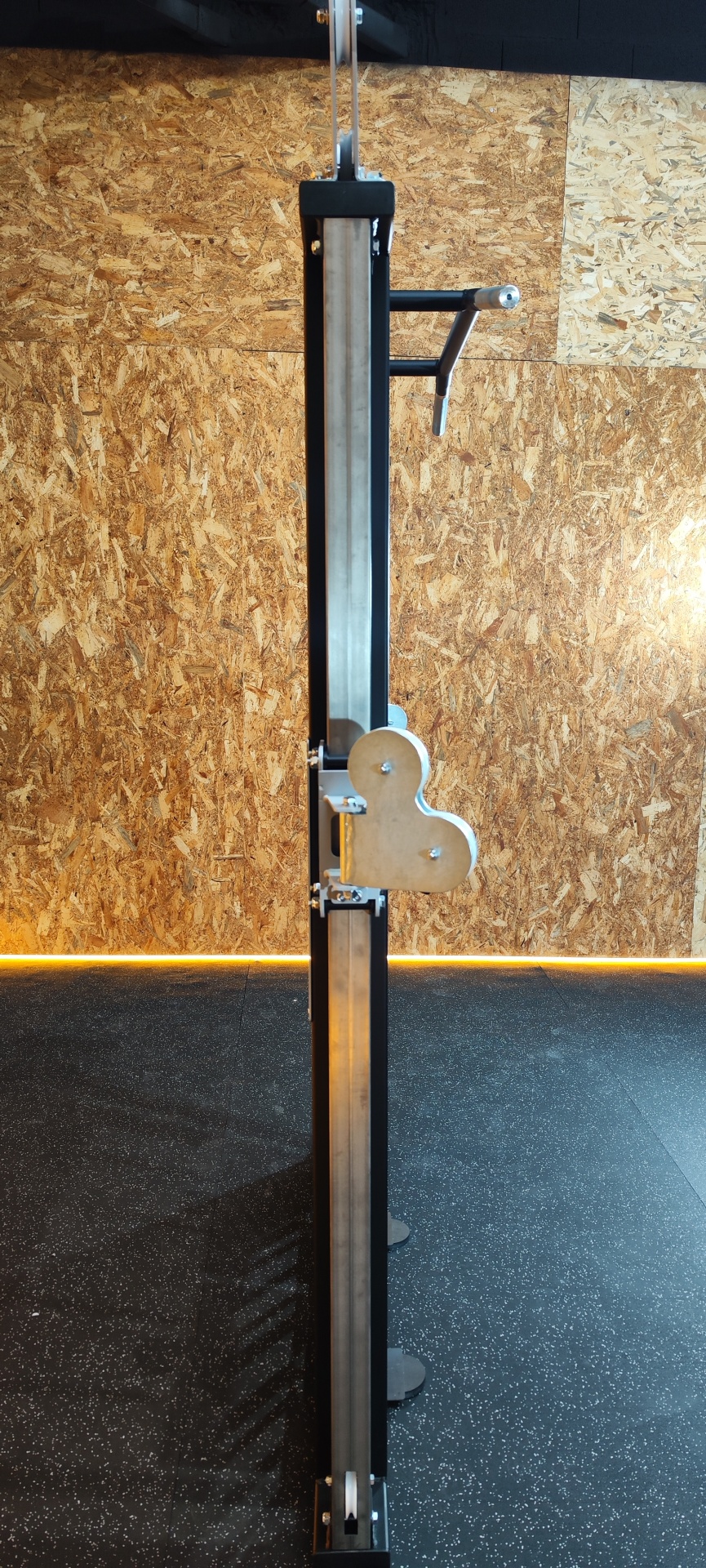 Torre de exercício vertical em metal com suporte ajustável e parede de madeira aglomerada