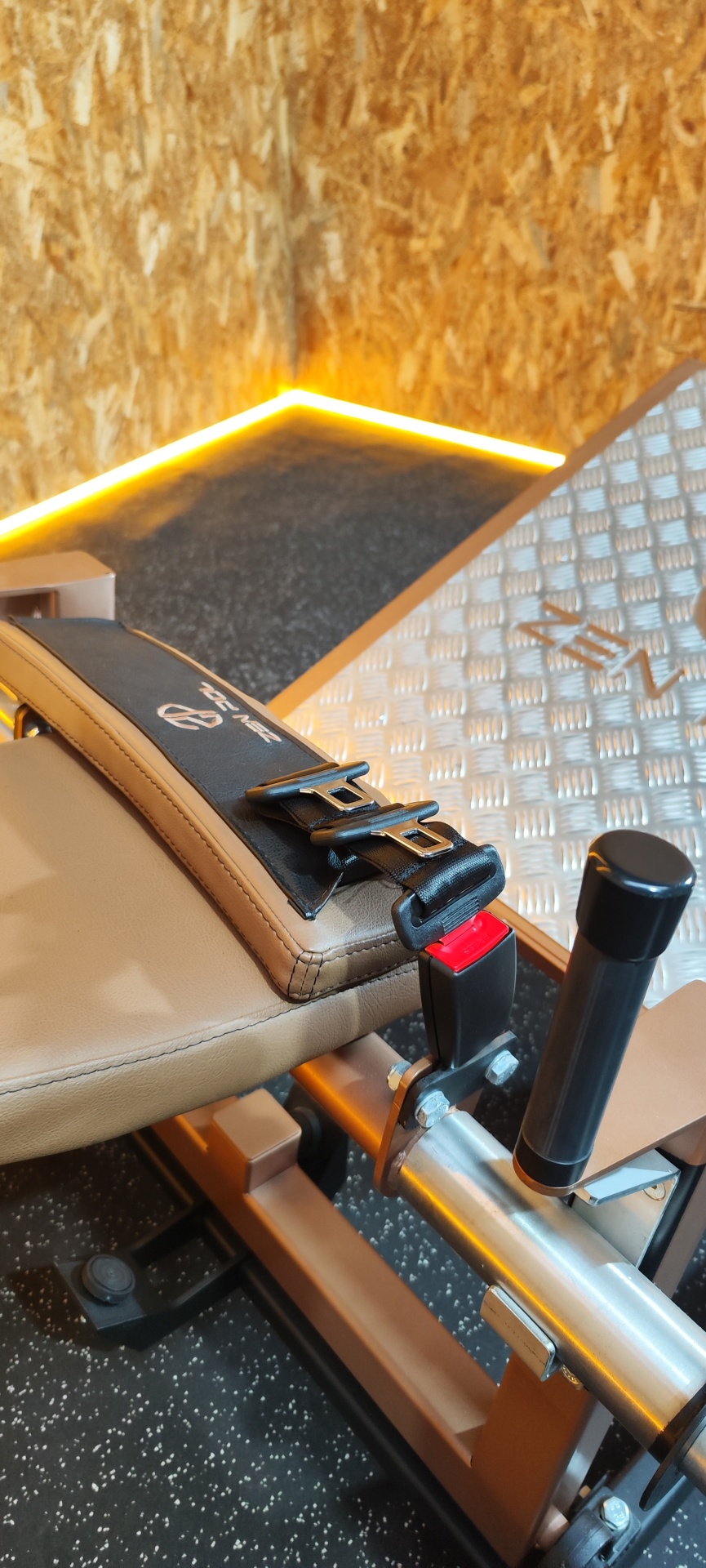 Banco de treino estofado bege e preto com correia com fivela e texto TENZ