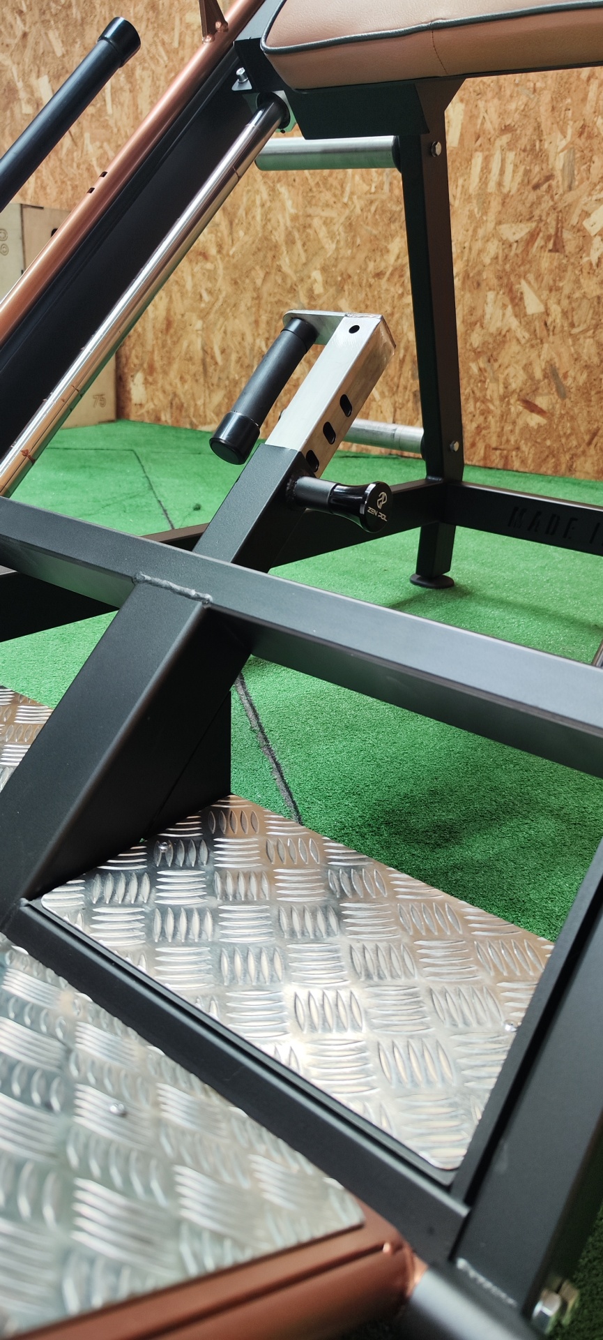 Equipamento de ginásio com estrutura metálica preta e plataforma antiderrapante