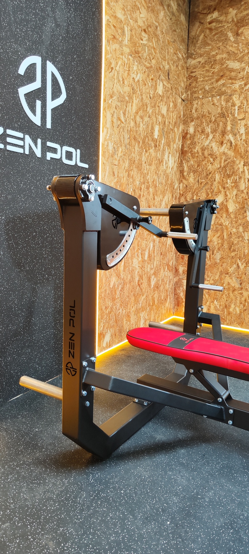 Bancada de musculação preta com banco vermelho e logo ZEN POL em parede