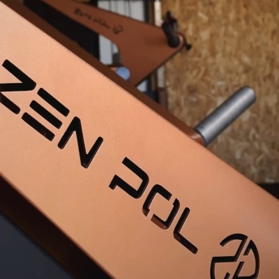 Máquina de exercício cobre com texto 'ZEN POL' e logotipo preto