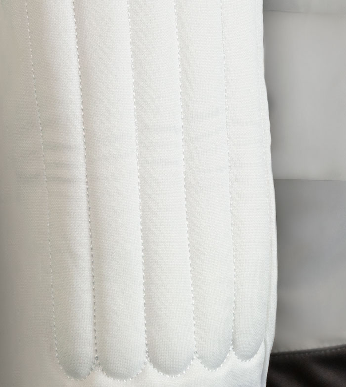 Tecido branco acolchoado com costuras verticais onduladas