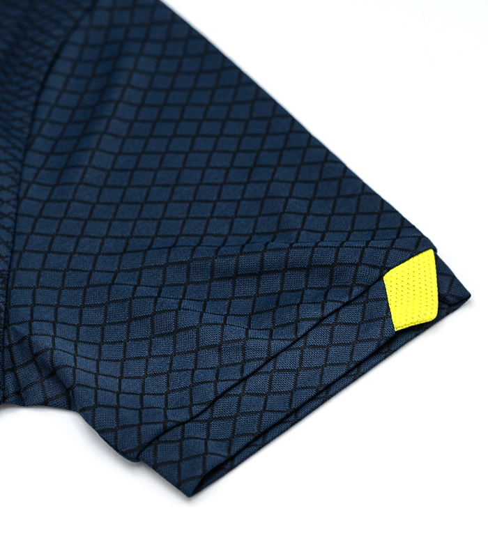 Manga de t-shirt azul escura com padrão de losangos e etiqueta amarela