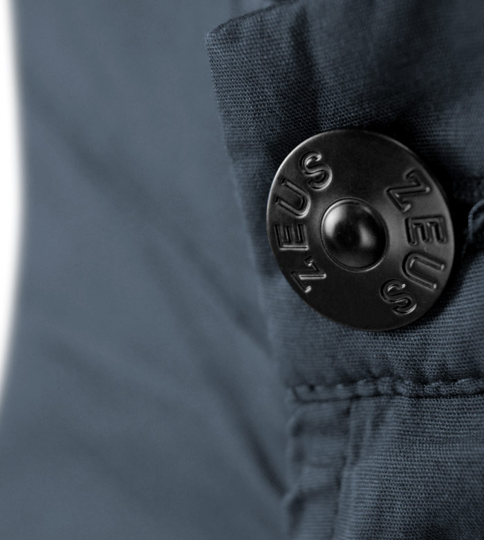 Botão metálico preto em tecido azul escuro de roupa