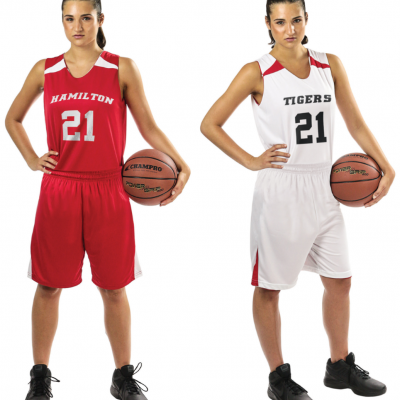 Duas jovens com fatos de basquetebol, uma de vermelho com HAMILTON e outra de branco com TIGERS, com bolas CHAMPRO.