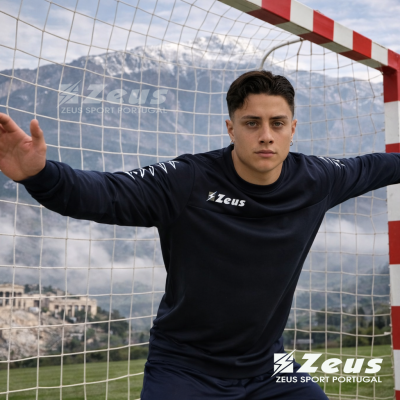 Jogador de futebol em roupa desportiva azul escura Zeus em frente a baliza de andebol ao ar livre
