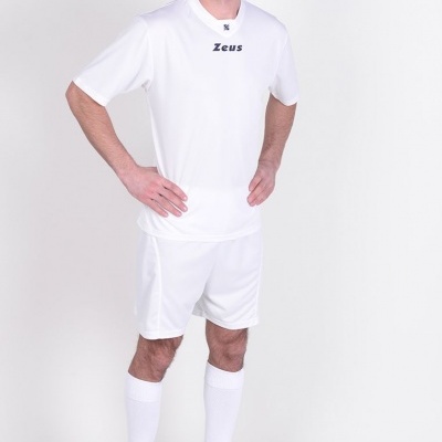 Homem com fato desportivo branco e sapatilhas pretas em fundo branco