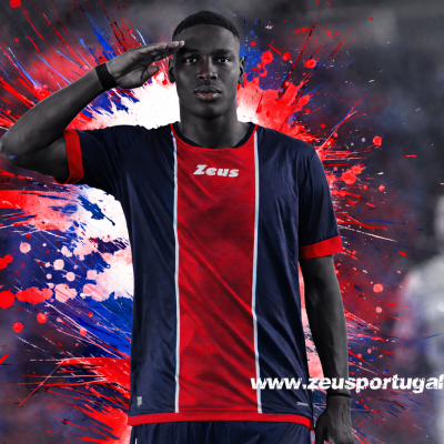 Jogador de futebol com camisola azul e vermelha com logótipo Zeus e fundo abstrato colorido