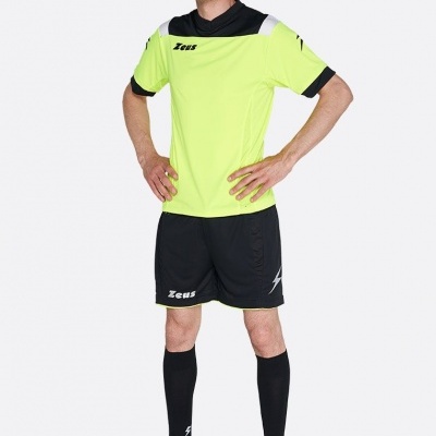 Homem com equipamento desportivo amarelo fluorescente e preto, calções pretos, meias pretas e sapatilhas azuis.